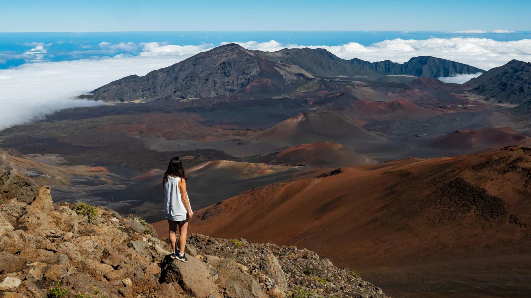 A paranomic view of Haleakala summit with a woman standing on a rock.